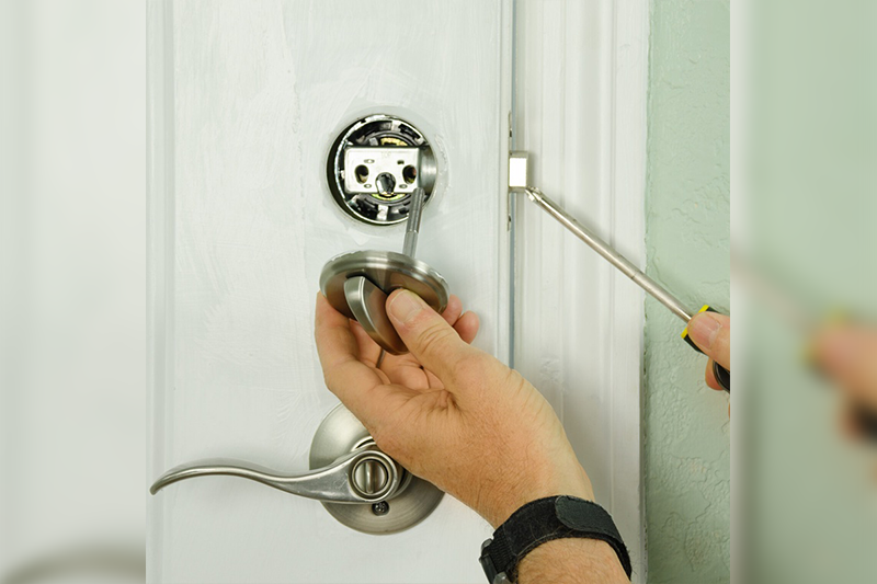 A person is holding the door knob of their home.