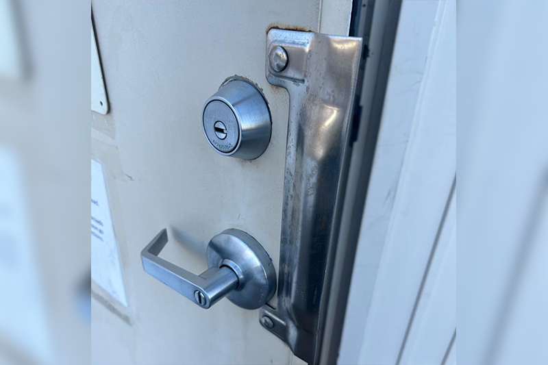 A door handle and lock on the outside of a building.