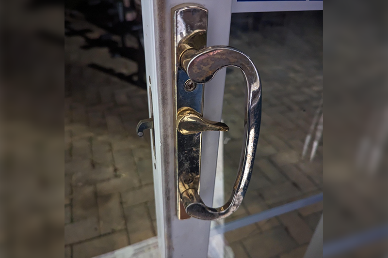 A door handle is shown on the outside of a house.