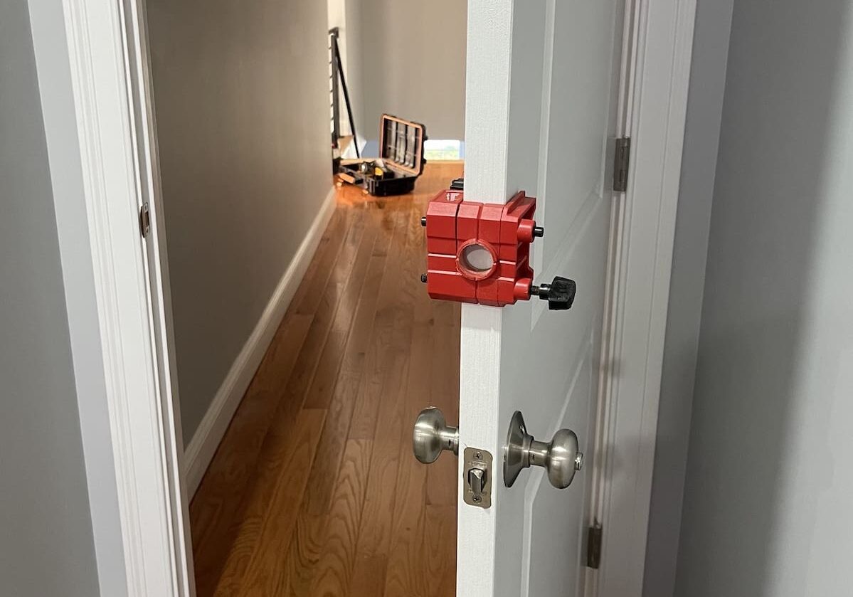 Red door installation tool in hallway.