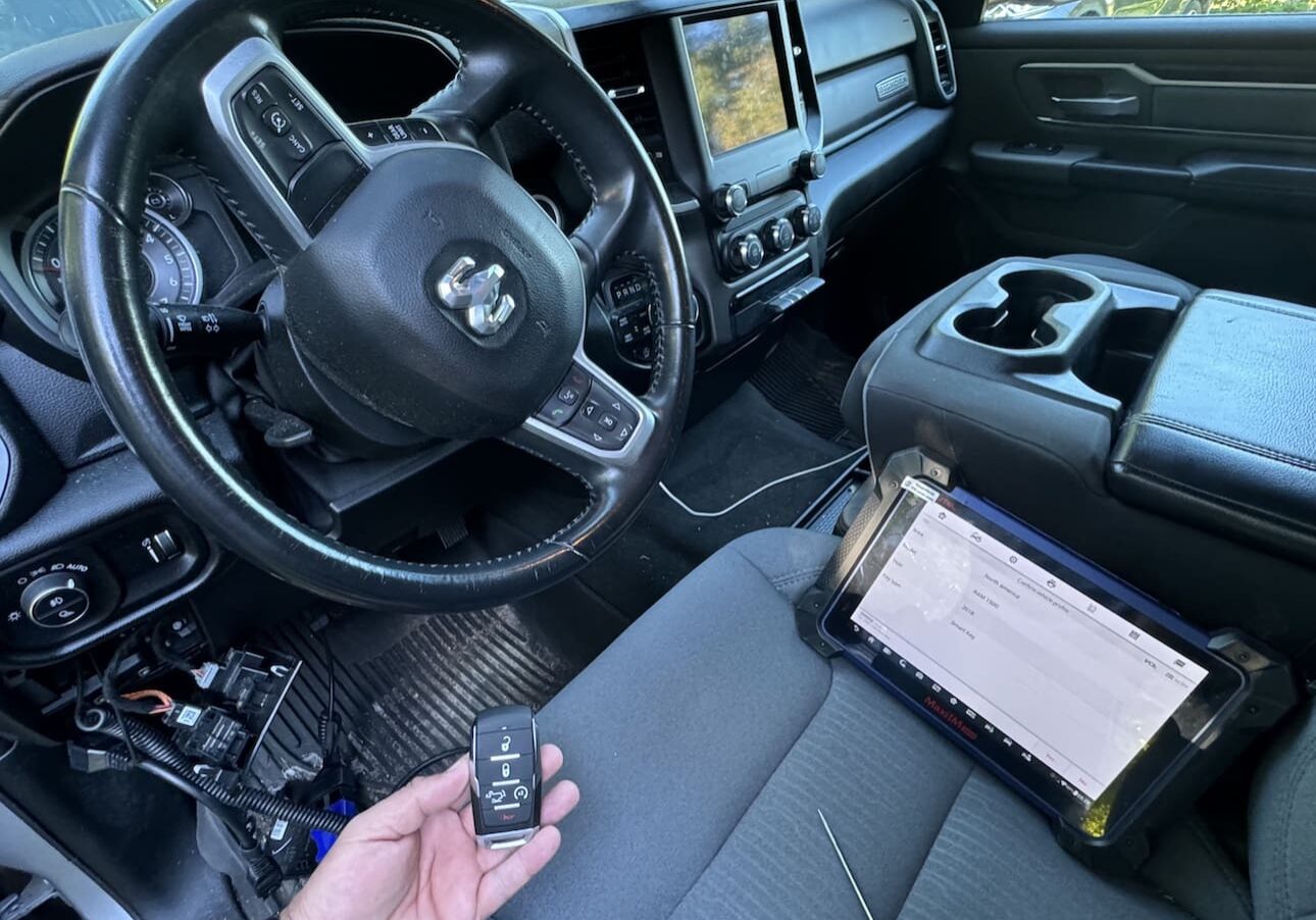 A person is holding a remote in the driver 's seat of their truck.