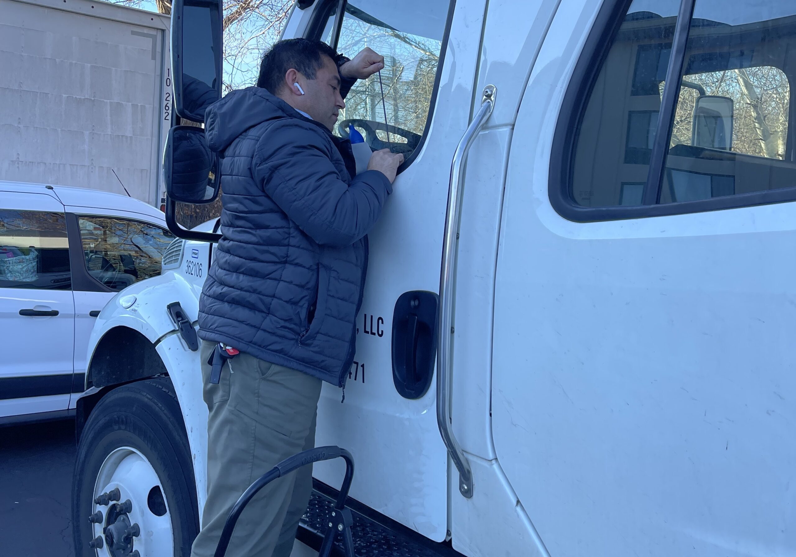 A man standing in the window of a truck.